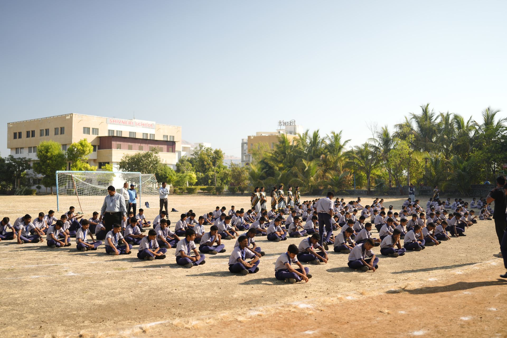 Students gathered on the ground in front of the school building
